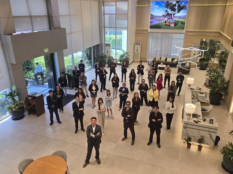 Members of Team Elite standing in the DMCI Homes showroom atrium